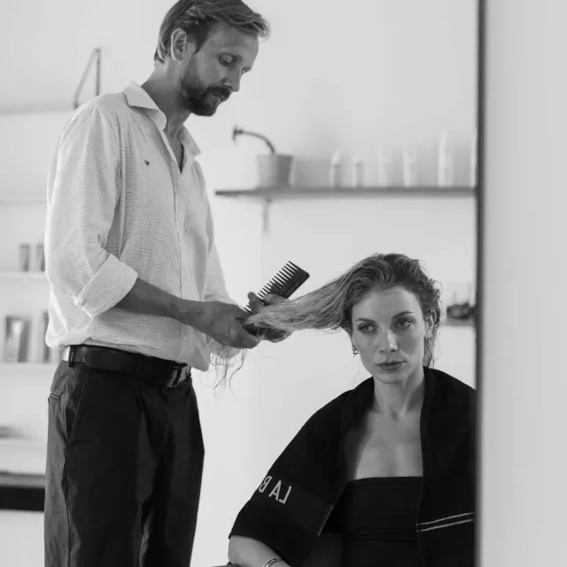 Czesanie długich włosów klientki przed lustrem — @khcsalon na Instagramie (nowa karta)